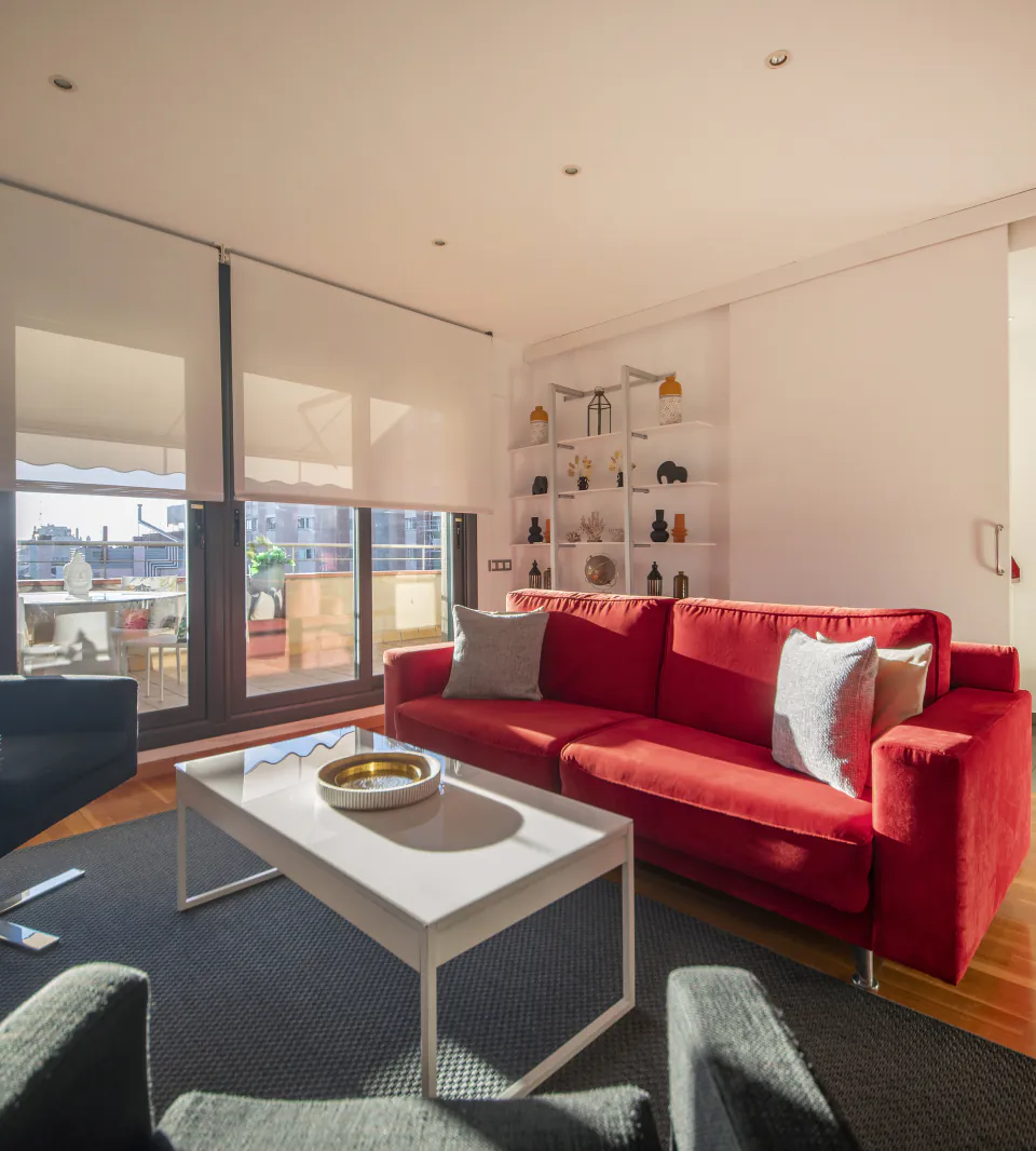 Suite Divina living room with a red sofa opening onto the private terrace