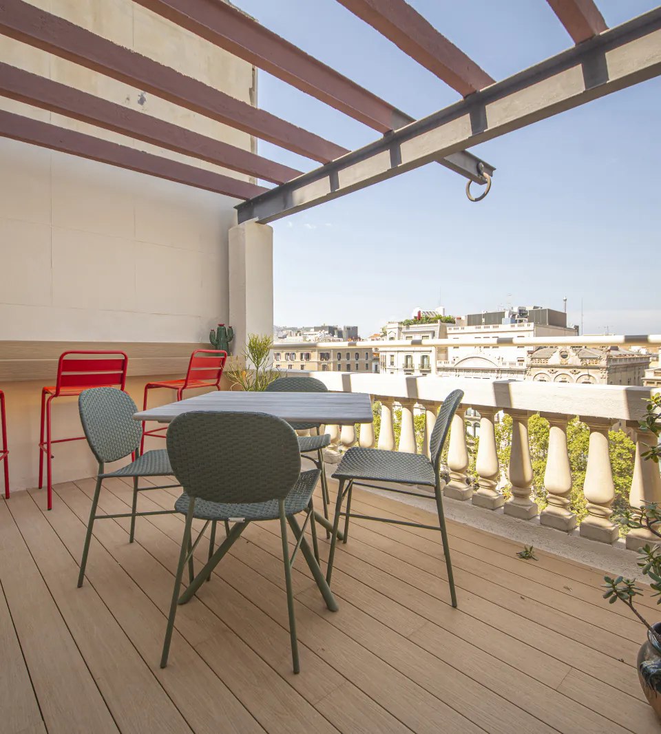 Suite Laia private terrace with a dining table and views across Barcelona
