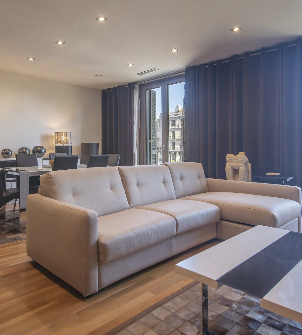 Suite Sagrada living and dining area beside Passeig de Gràcia balcony windows