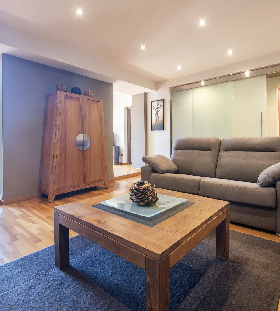Suite Sol&eacute;a living room with timber furniture, an open kitchen and balcony light
