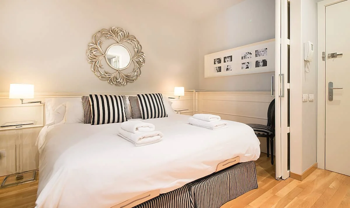 Casa Verdú principal bedroom with double bed and tall balcony windows