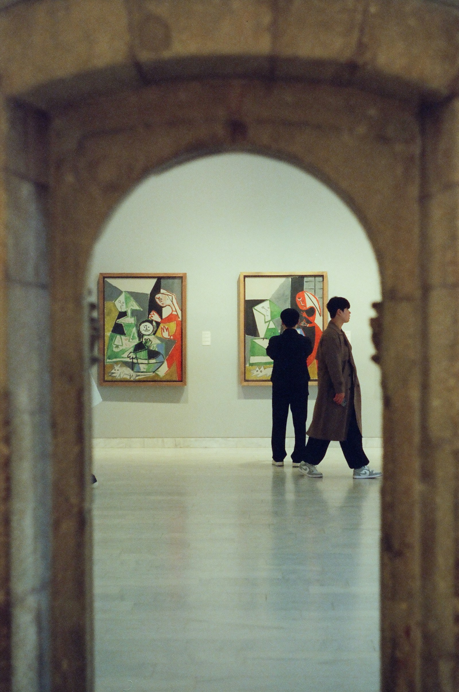 Visitors considering paintings in a Barcelona art gallery