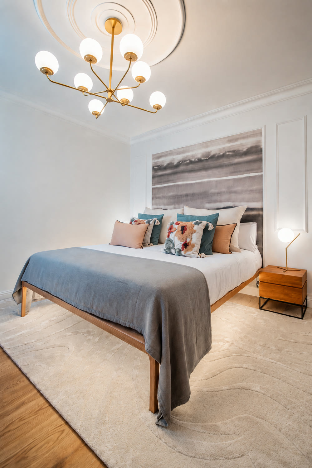 PDG15 apartment bedroom suite with brass chandelier, layered cushions, and soft rug