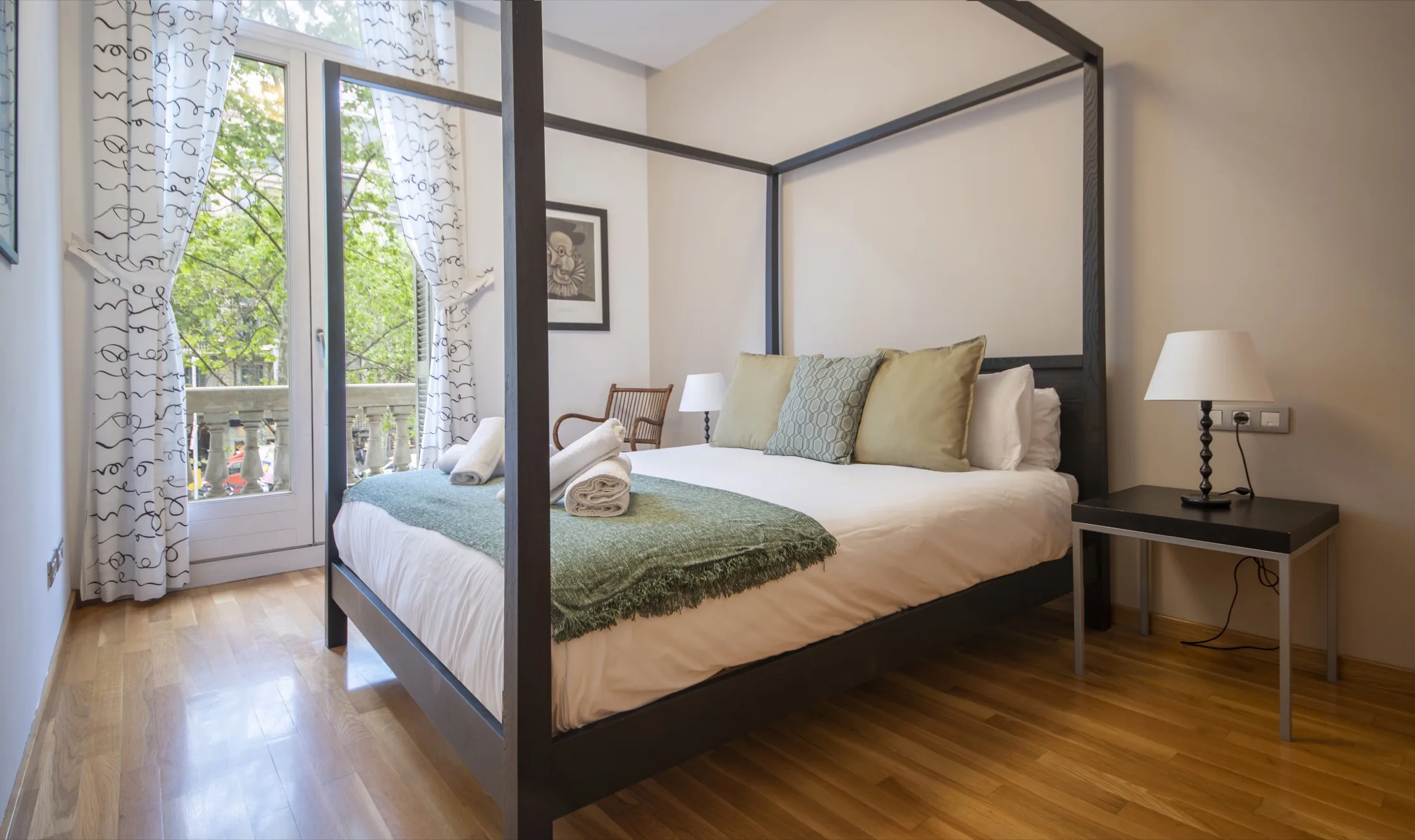 Suite Bella principal bedroom with double bed and tall balcony windows