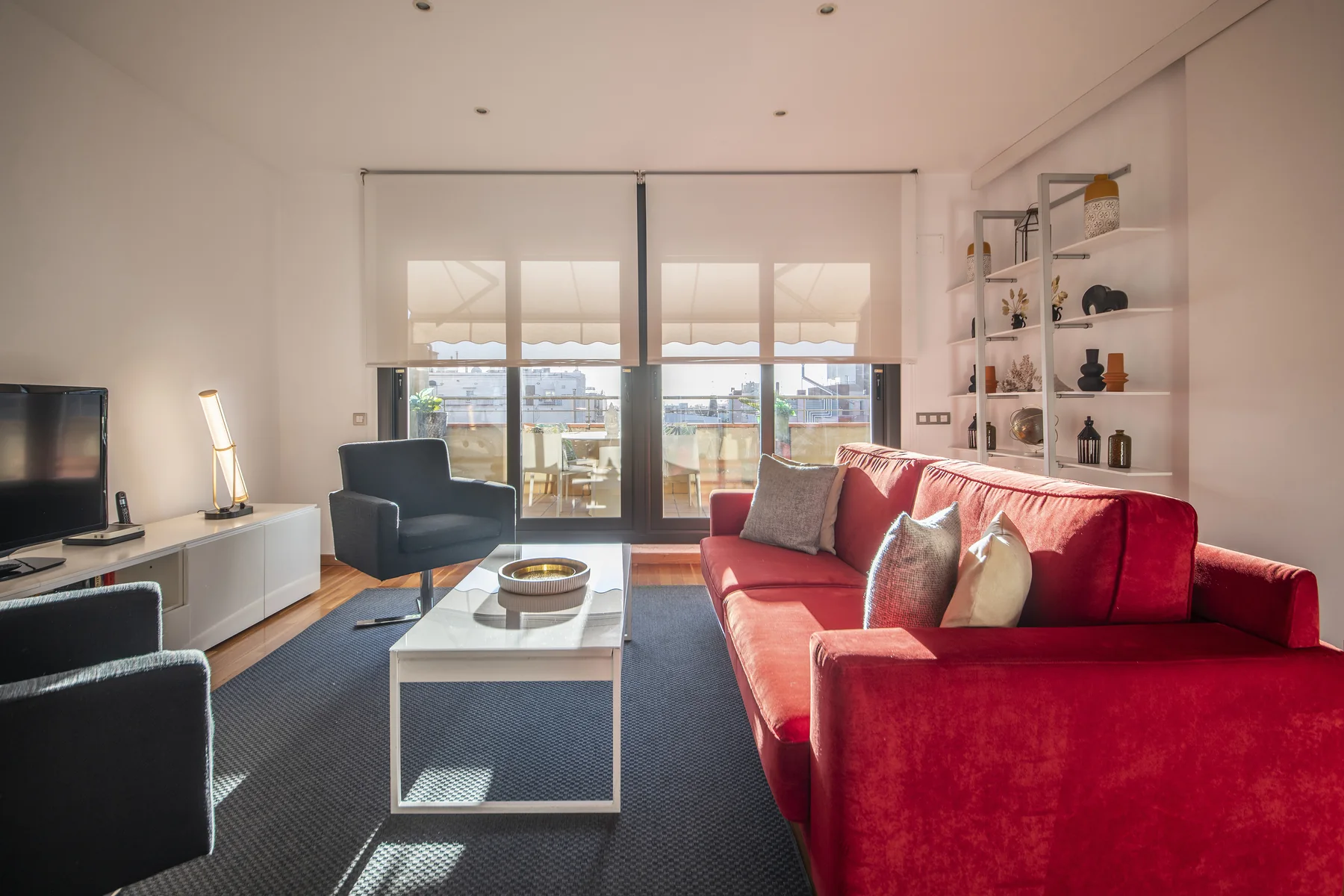 Suite Divina red sofa and city-facing windows