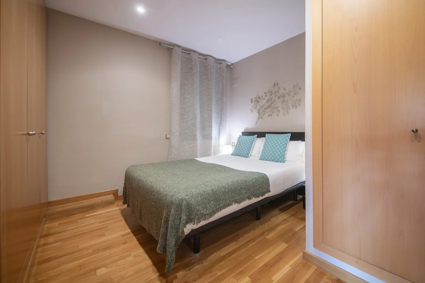 Suite Divina principal bedroom with double bed and tall balcony windows