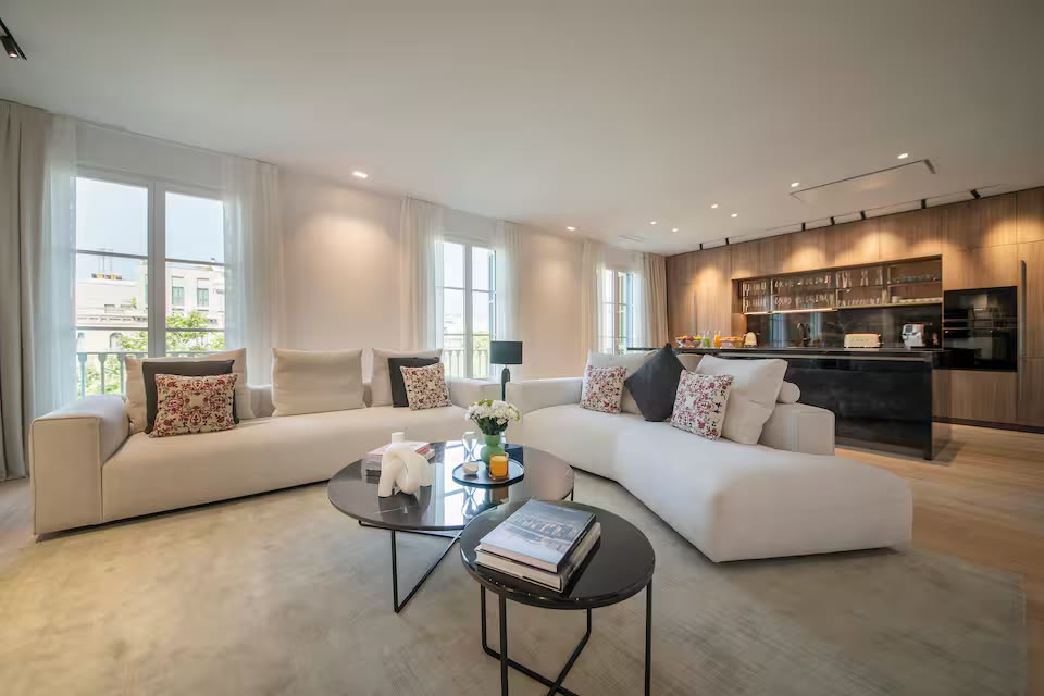 Suite Prestige living room with pale sofas and tall windows over Passeig de Gràcia