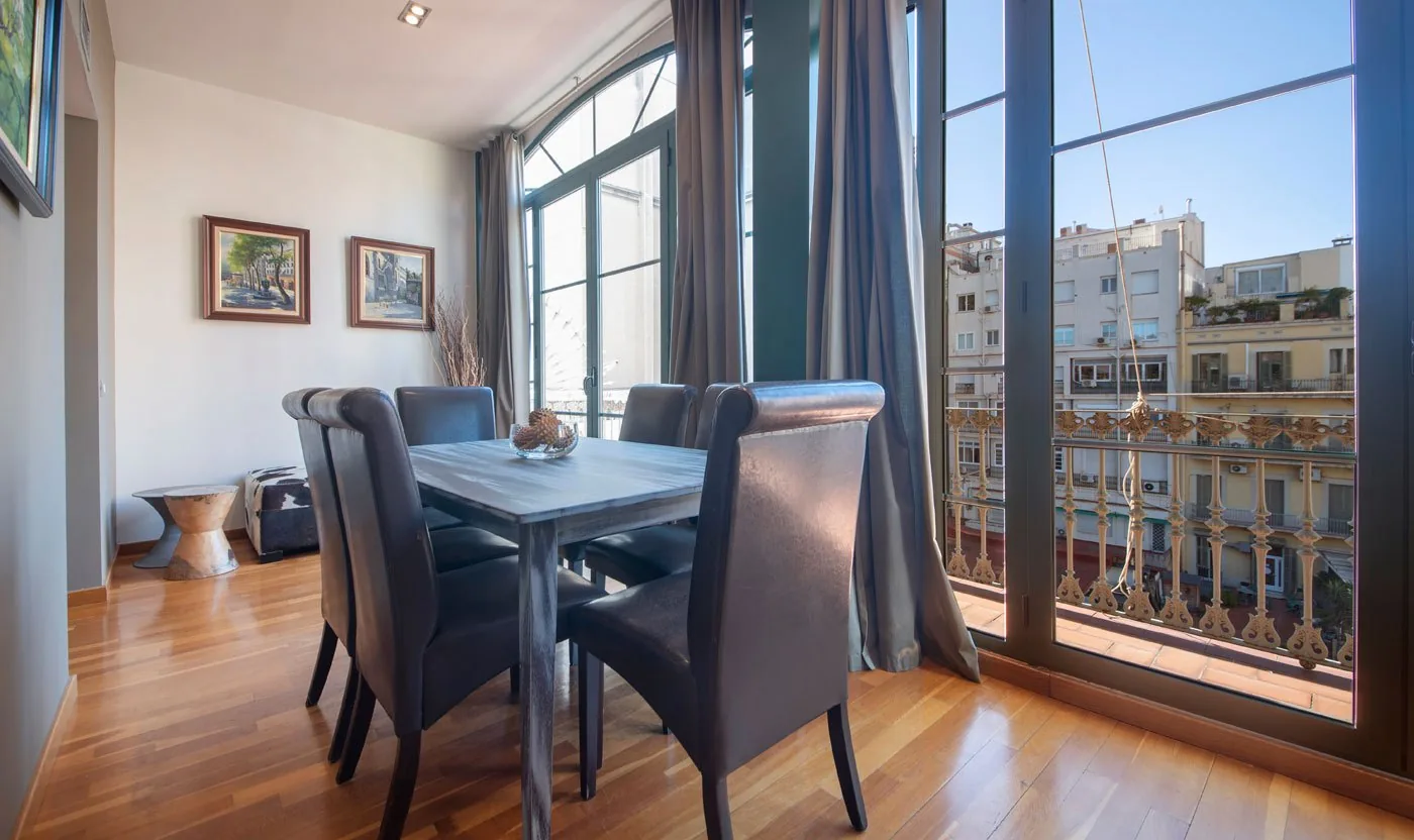 Dining table framed by the balcony windows in Suite Sol&eacute;a