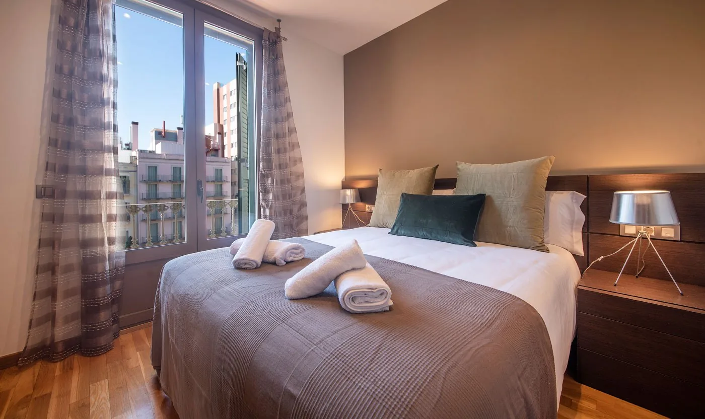 Principal bedroom in Suite Sol&eacute;a with a queen bed and city-facing window